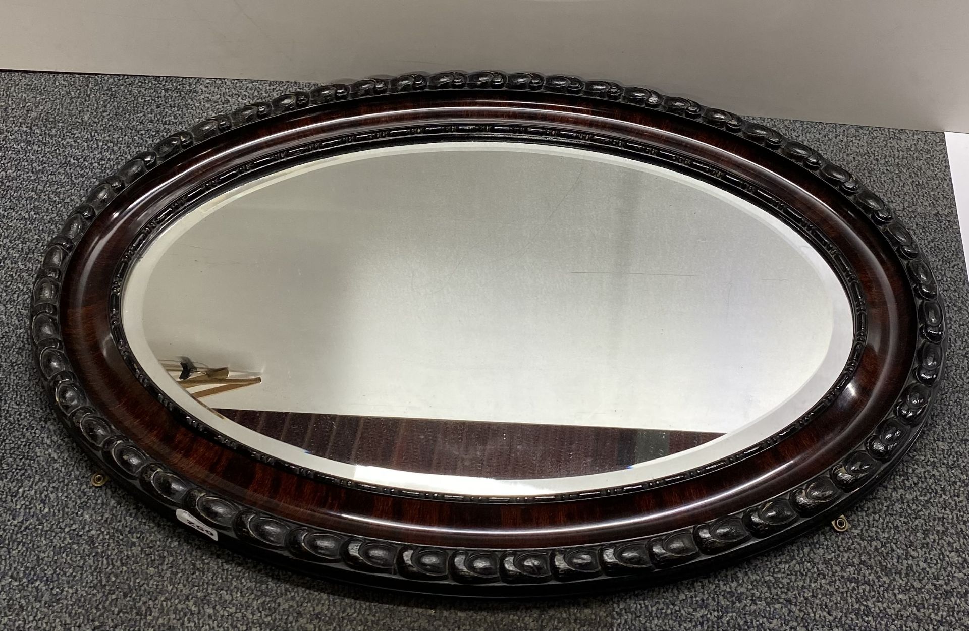 A 1920's oval framed mirror, W. 83cm.