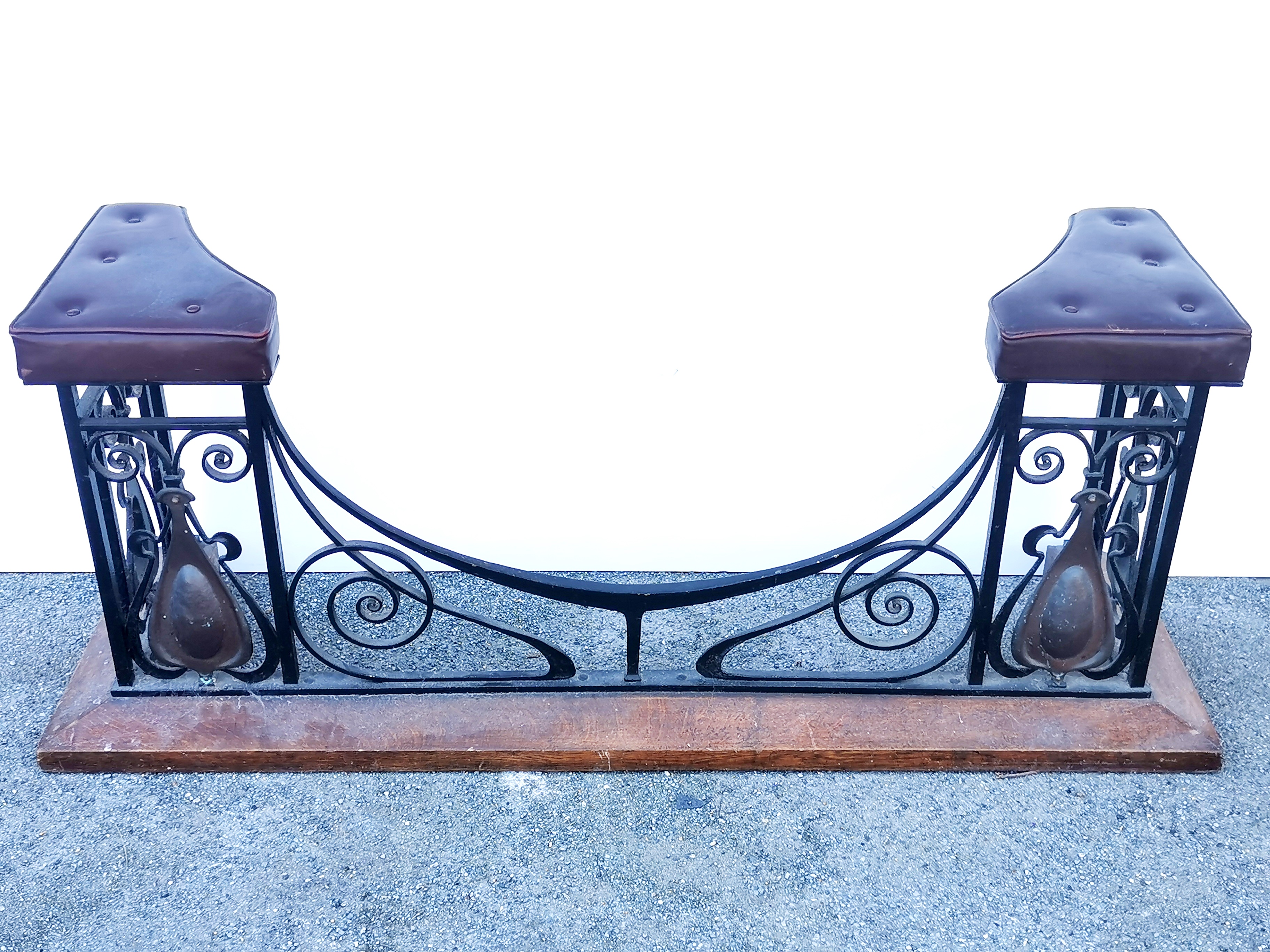 A large Art Nouveau 20thC upholstered iron and oak fireplace fender seat, W. 180cm.