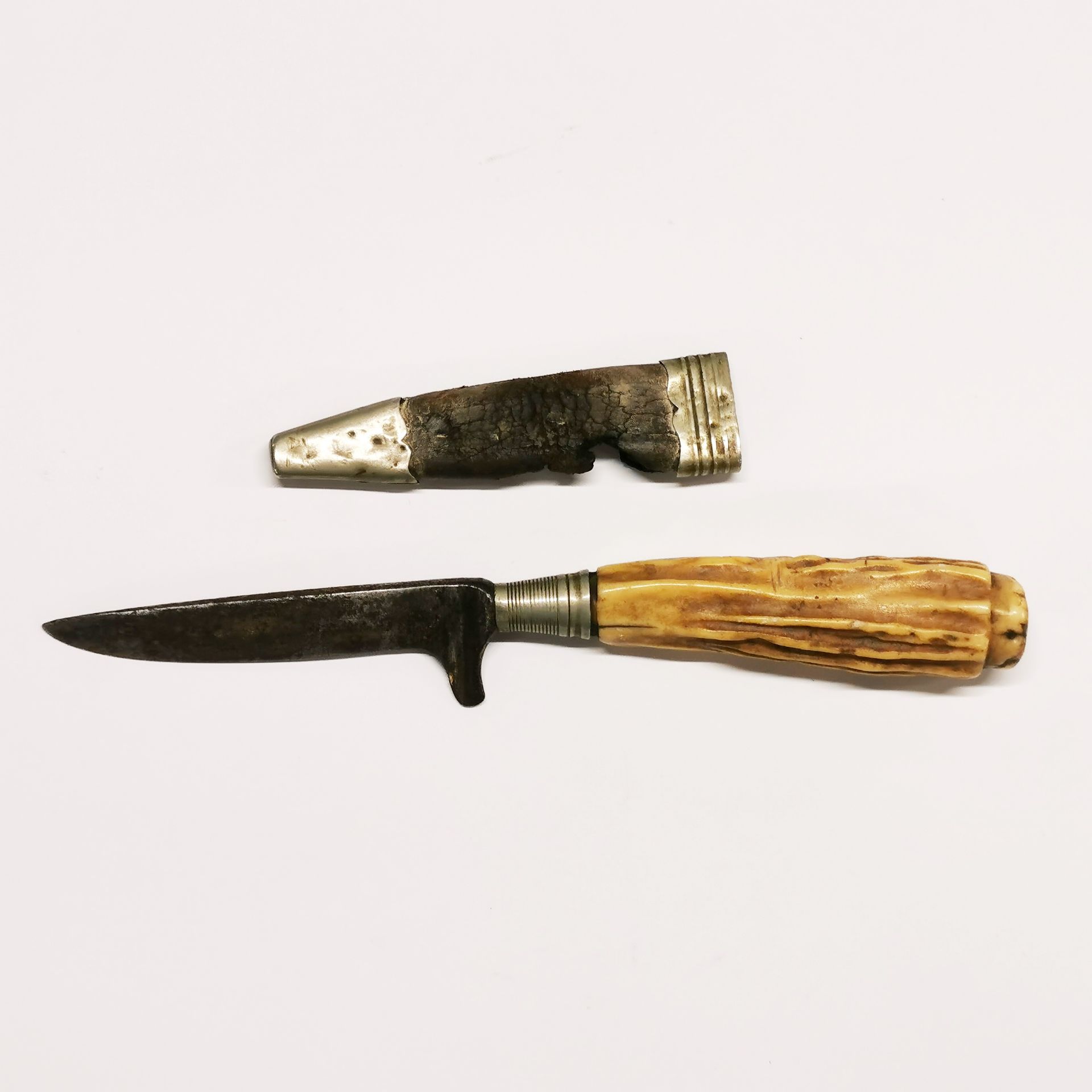 A Scottish antler handled dirk knife with a white metal and leather sheath (A/F)