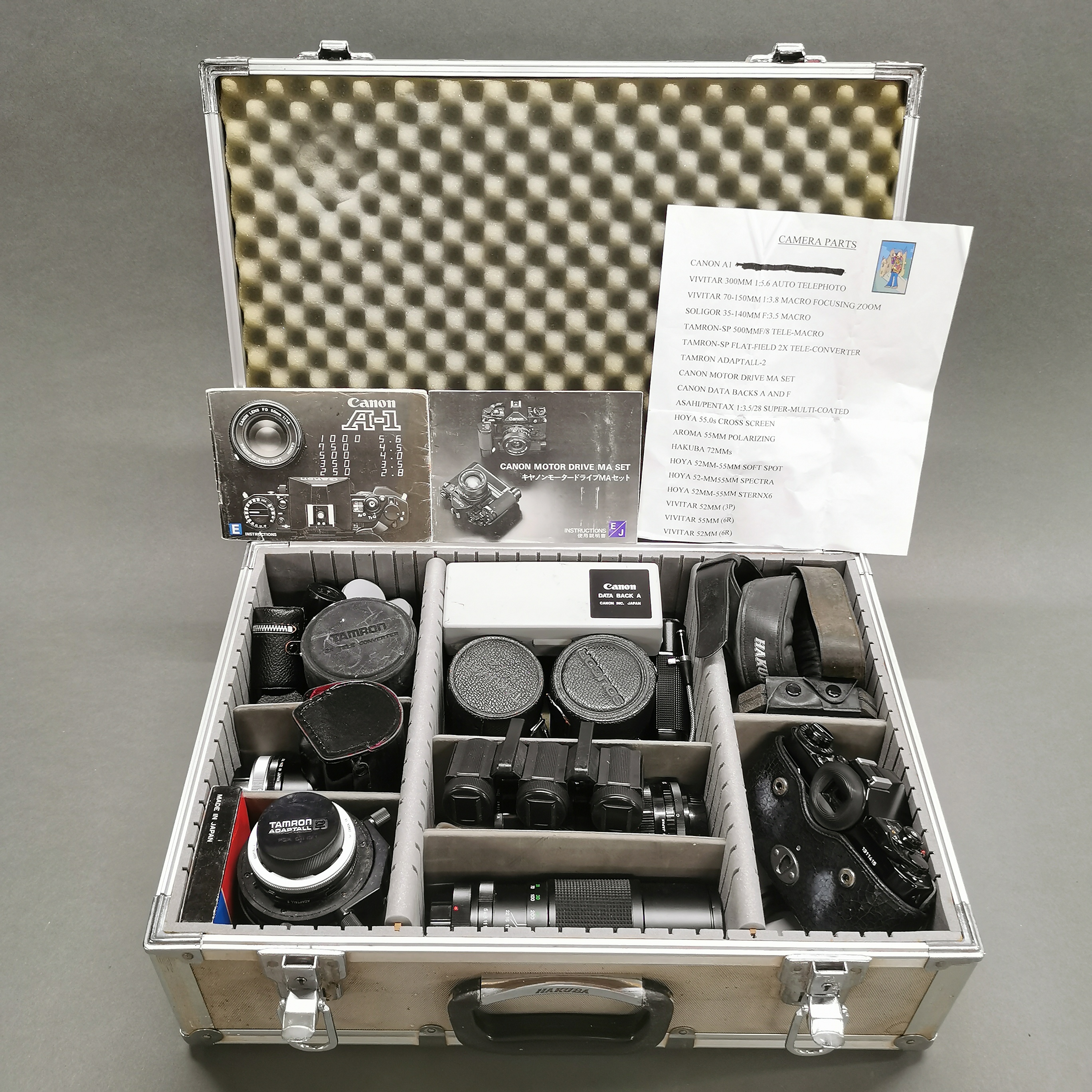 A photographic case containing a Canon A-1 SLR camera, together with a group of mixed lenses etc.