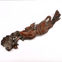 A Chinese carved wooden rui sceptre in natural form of lotus entwined with "cash" L. 43cm.
