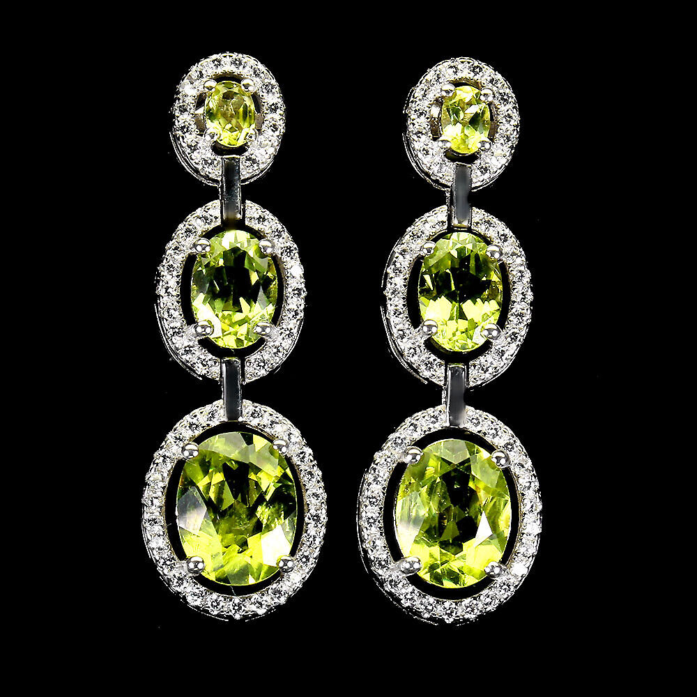 A pair of 925 silver drop earrings set with oval cut graduated peridots and white stones, L. 3.