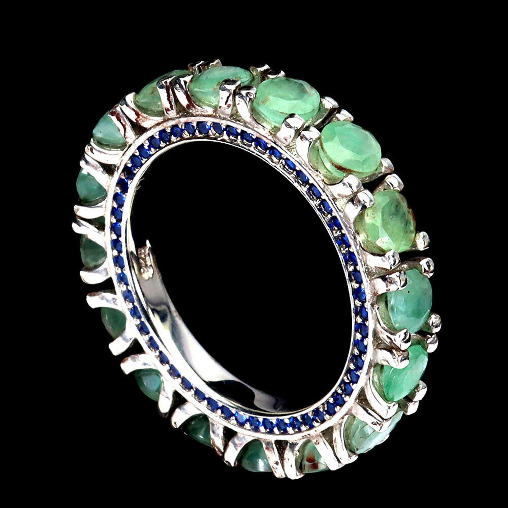 A 925 silver full eternity ring set with emeralds and sapphire set shank, ring size O.