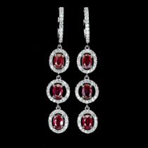 A pair of 925 silver drop earrings set with oval cut rubies and white stones, L. 5.2cm.