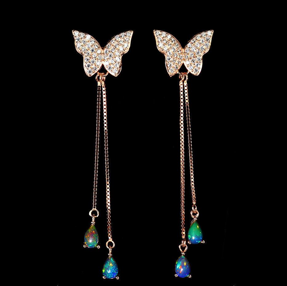 A pair of rose gold on 925 silver butterfly shaped drop earrings set with opals, L. 6cm.