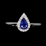 A 925 silver ring set with a pear cut sapphire and white stones, ring size M.