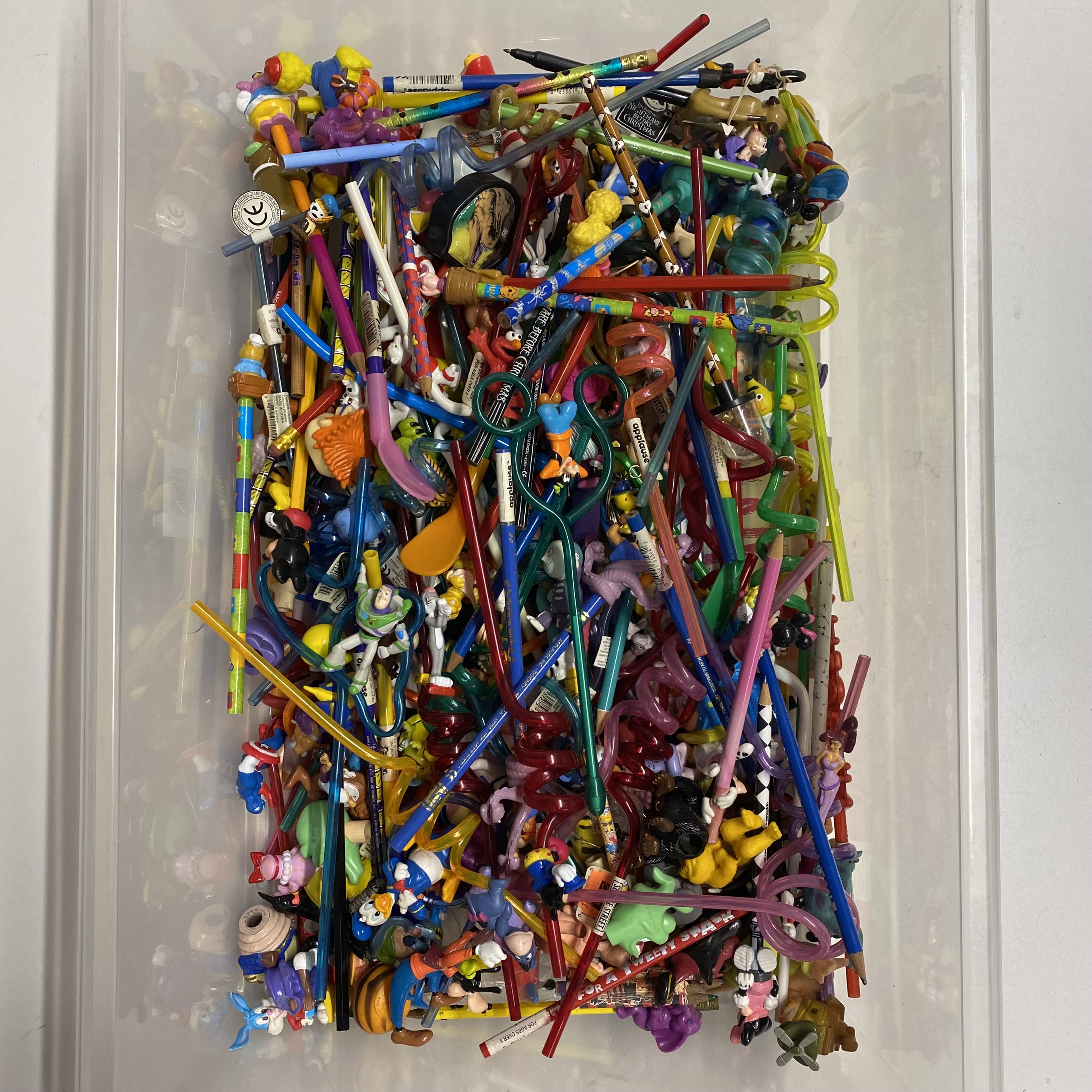 A collection of mostly Disney pencils including tops and novelty straws.