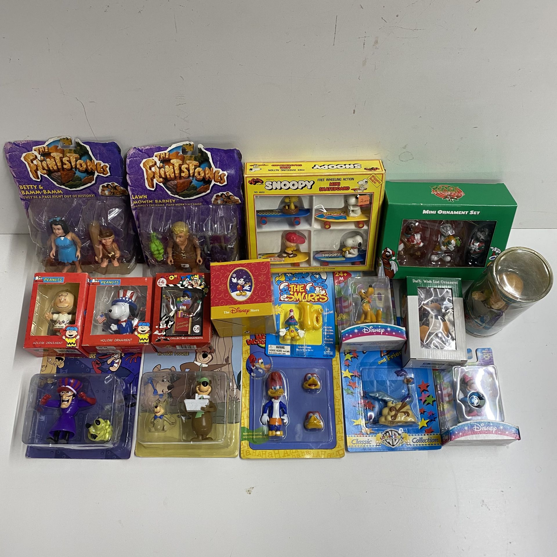 A box containing various sealed Disney and Warner Bros characters plus others includ