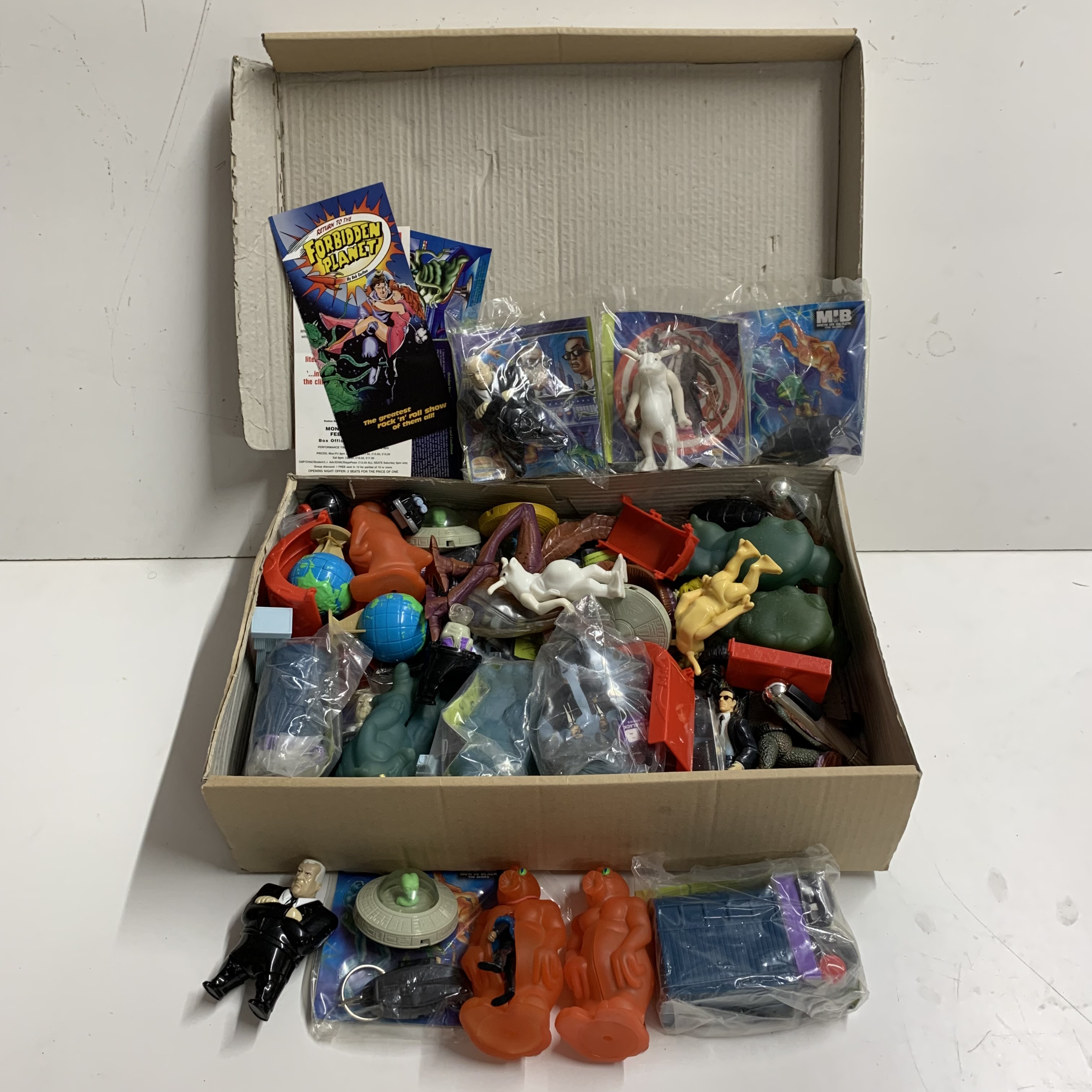 A quantity of Men in black Burger King toys and others.