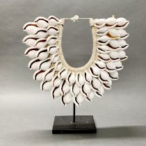 A large mounted tribal cowrie shell neck piece, H. 47cm W. 42cm.