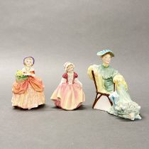 A group of three Royal Doulton figurines.