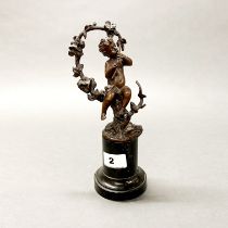An early 20th Century bronze figure of a cherub playing a flute on a marble base, H. 23cm.