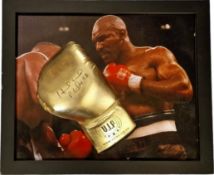Evander Holyfield signed Gold Boxing Glove displayed on a colour photo of Evander Holyfield in
