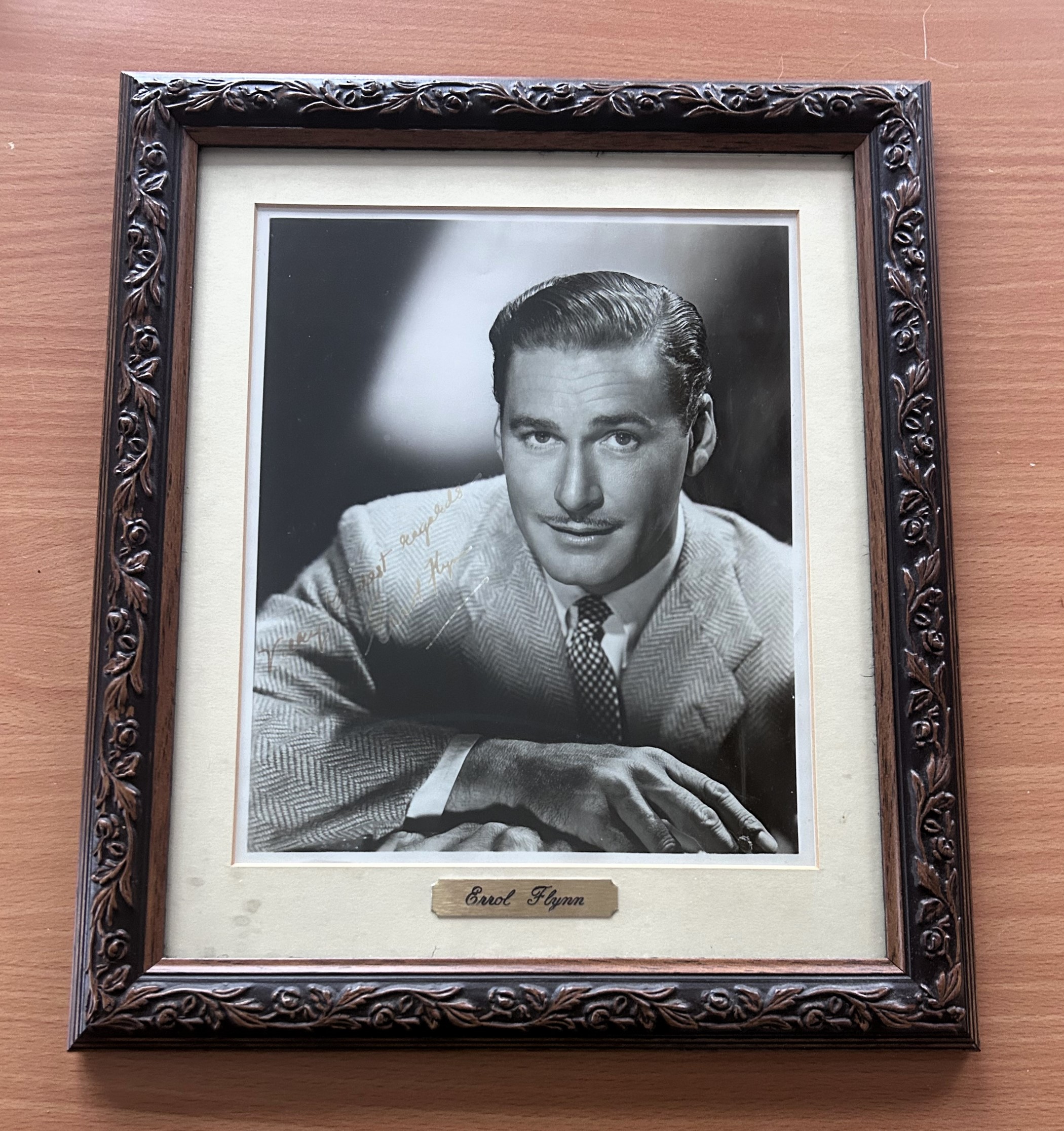 Errol Flynn signed mounted and framed black and white photo, with gold name plaque below. Measures