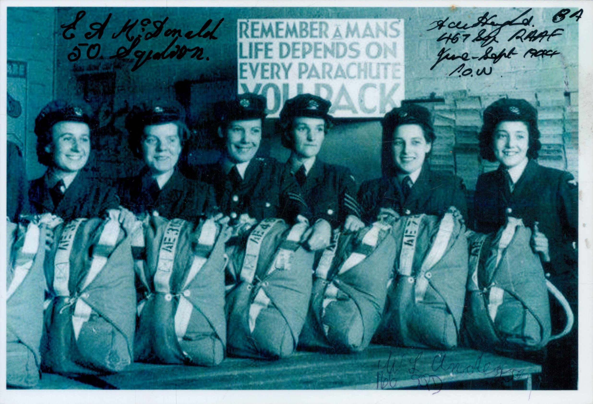 WRAFs lined up with Parachutes in front of sign Remember a Mans Life Depends on every Parachute