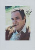 Burt Reynolds signed 12x8 colour photo page. Good condition. All autographs come with a