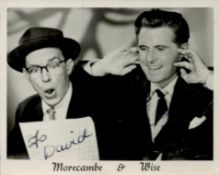 Morecambe and Wise signed 3x2inch black and white photo. Signed on dark part of image. Good