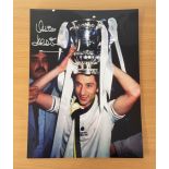 Football. Ossie Ardiles Signed 16x12 colour photo. Photo shows Ardiles with a trophy on his head.