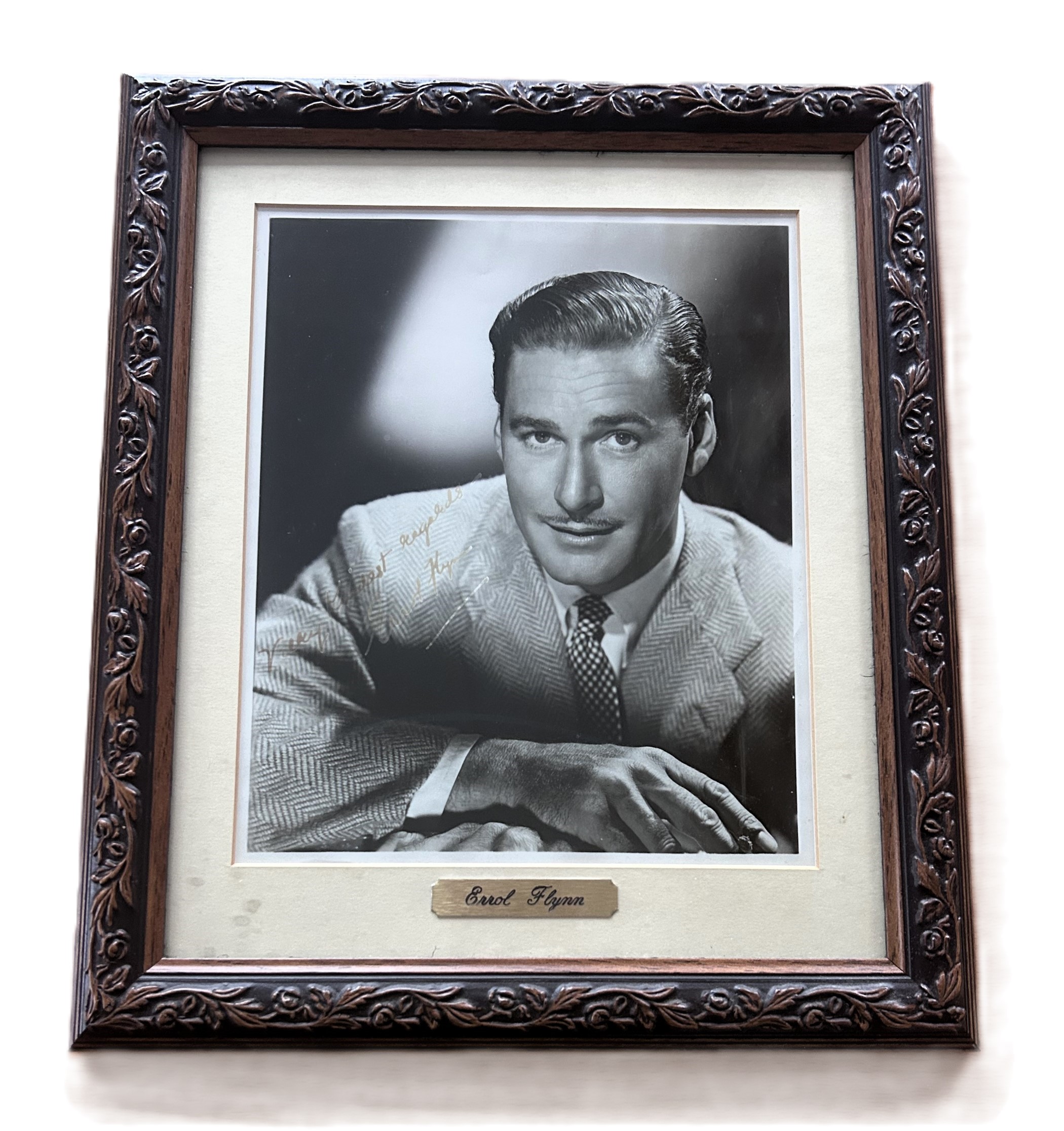 Errol Flynn signed mounted and framed black and white photo, with gold name plaque below. Measures