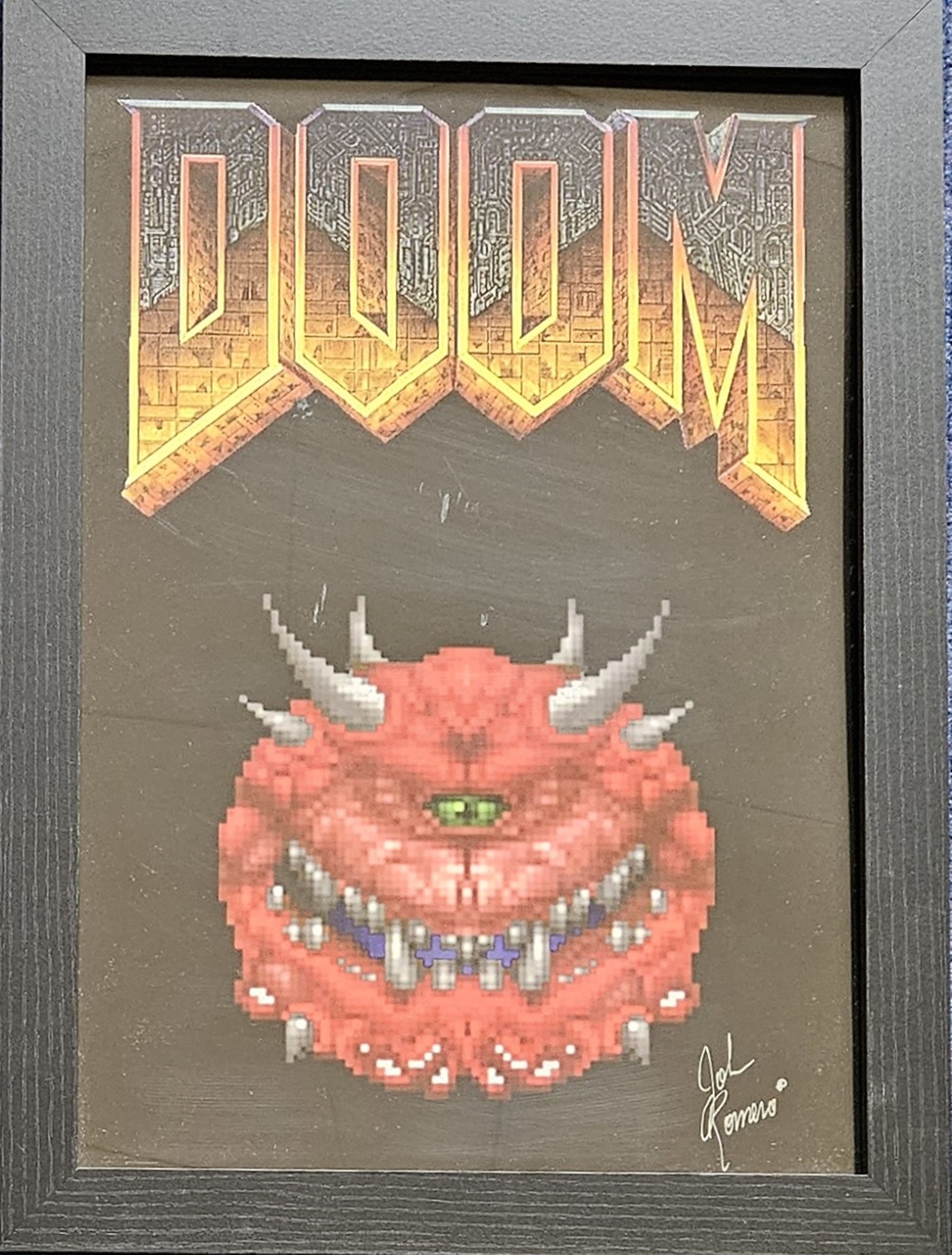 John Romero signed Doom illustrated piece. Framed to approx. size 18x14inch. Good condition Est.