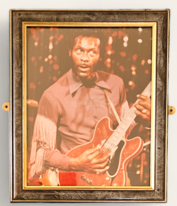 Chuck Berry framed colour photo; Chuck Berry plays his guitar in purple wester style shirt.