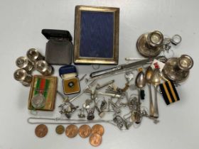 A small collection of silverware including a photograph frame, a pair of library candlesticks,