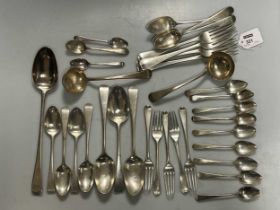 A harlequin collection of Old English pattern silver flatware, including a basting spoon, 1281.8g (