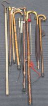 A selection of walking sticks and umbrellas, some with carved decoration (qty)