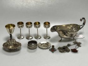 A collection of silverware including a sauce boat, pin trays, travelling chalice and paten etc,