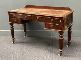 A Victorian writing desk, with four drawers, leather inset top, on reeded legs and casters, 118cm