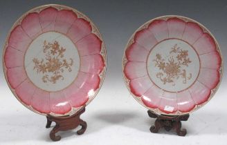 A pair of Chinese lotus leaf pattern plates with a pink glaze and floral centres, 28cm (both badly