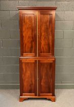 A reproduction mahogany cabinet enclosed by two pairs of doors divided by a slide, 203 x 82 x 51cm