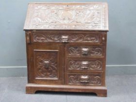 A late Victorian oak bureau, the fall front carved with dragons, with cupboard and drawers below, on