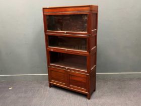 A mahogany 4 section stacking bookcase, a cupboard to the lower section, 150cm high, 86cm wide