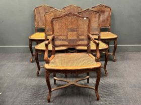 A set of six French dining chairs with caned backs and seats, on carved cabriole legs, one carver