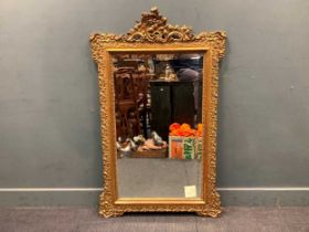 A late Victorian gilt wood wall mirror, the rectangular bevelled plate within a moulded frame