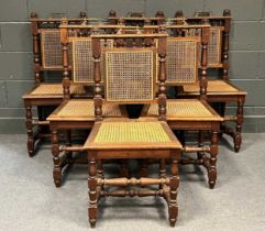 A set of 6 oak caned dining chairs, the top rails set with lion mask finials and brass handles