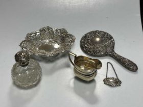 A small collection of silverware including a cream jug, bon bon dish, decanter label, hand mirror