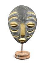 A contemporary patinated bronze face mask,