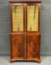 A reproduction mahogany cabinet the upper part enclosed by grille doors with panel doors under,