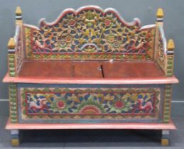 A brightly decorated continental bench seat, the carved back surmounted with four gilded pinacles.