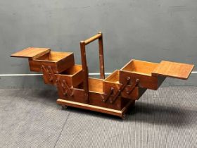 A mid-century cantilever sewing box with six compartments and single handle 61 x 58 x 28cm