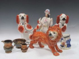 A large Staffordshire model of a lion, a Staffordshire model of a huntsman, a pair of