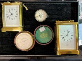 A striking carriage clock, a further carriage clock, a cased travelling barometer and a travelling