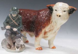 A Royal Copenhagen ceramic figure of a huntsman and his dog, a large ceramic bull (2)