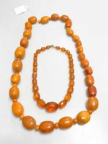 A string of amber beads, weight 176.8g, together with a string of reconstituted amber beads (2)