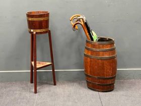 An early 20th century coopered oak barrel as a stick stand, another coopered planter on stand,