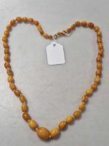 An amber bead necklace, weight 33.7g colour not consistent,  surface abrasion to multiple beads  one