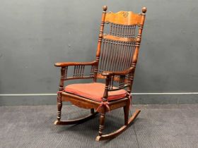 A late 19th century generously proportioned spindle back walnut rocking chair, possibly American.