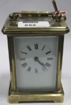 A brass carriage clock with Roman chapter ring 12cm high
